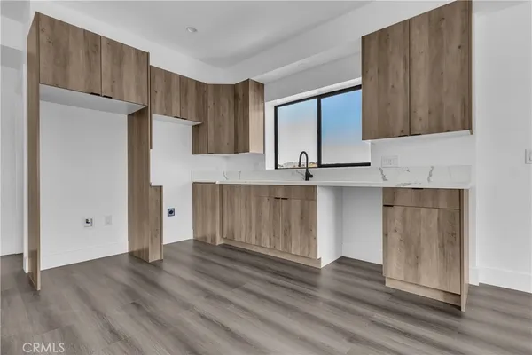 a view of kitchen with wooden floor and electronic appliances