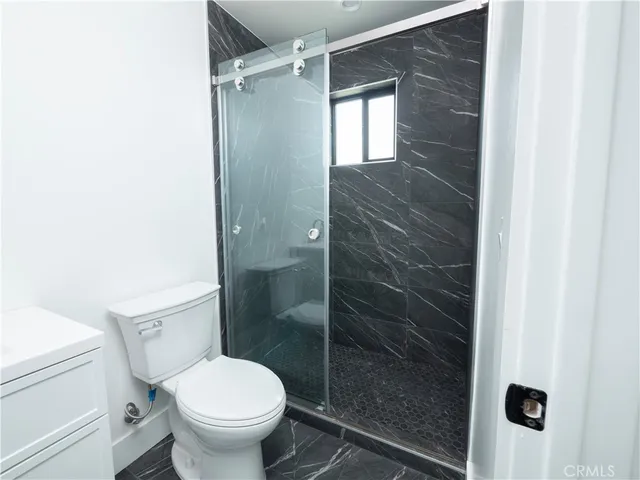 a bathroom with a toilet and a shower
