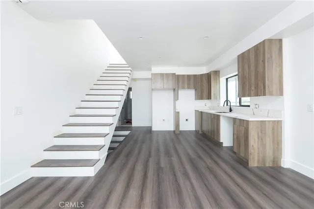 a view of a kitchen with wooden floor and electronic appliances