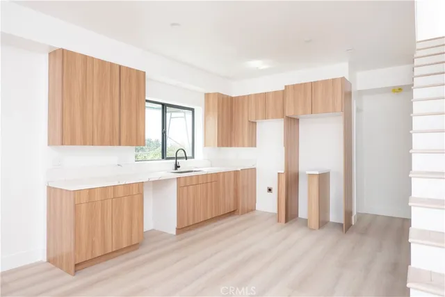 a kitchen with a sink a refrigerator and cabinets