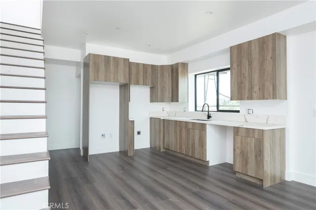 a large kitchen with a wooden floor and cabinets