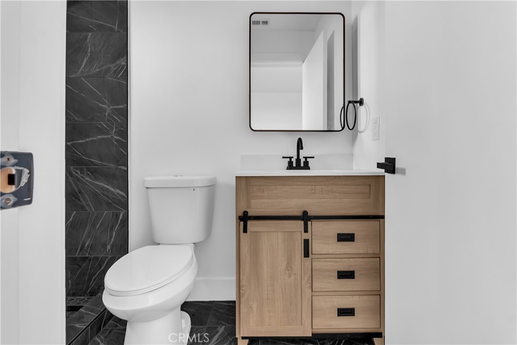 1571 Ricardo Street Los Angeles, CA 90033 - Photo 7 of 18 a bathroom with a toilet sink and mirror
