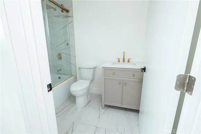 a bathroom with a granite countertop toilet a sink and a bathtub