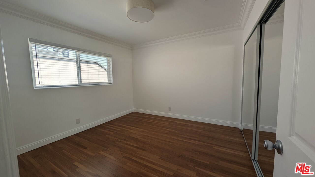 1728 South Robertson Boulevard, Unit 8 Los Angeles, CA 90035 - Photo 7 of 10 an empty room with wooden floor and windows