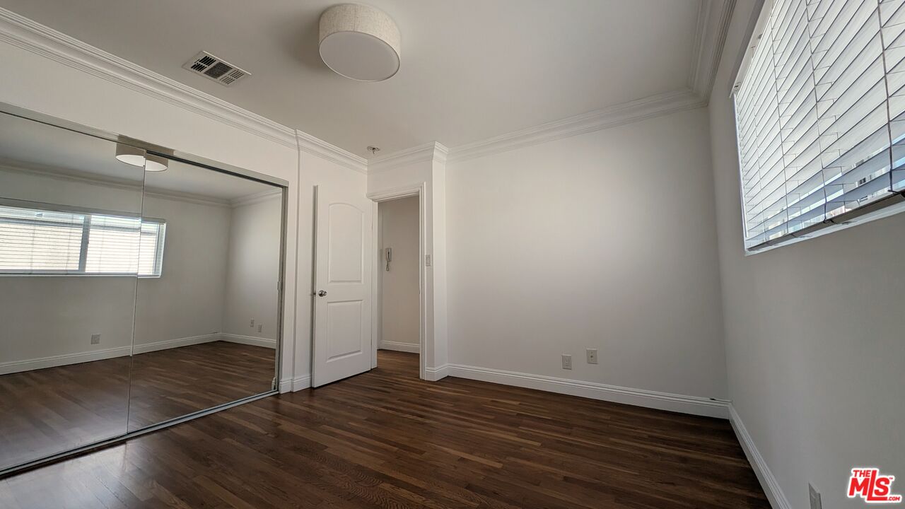 1728 South Robertson Boulevard, Unit 8 Los Angeles, CA 90035 - Photo 8 of 10 an empty room with wooden floor and windows
