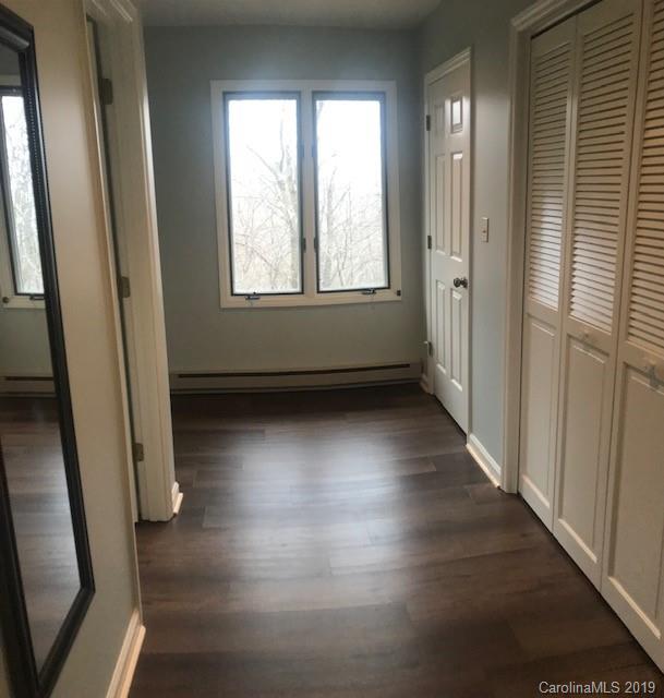 212 Pine Ridge Road Beech Mountain, NC 28604 - Photo 20 of 27 an empty room with wooden floor and windows