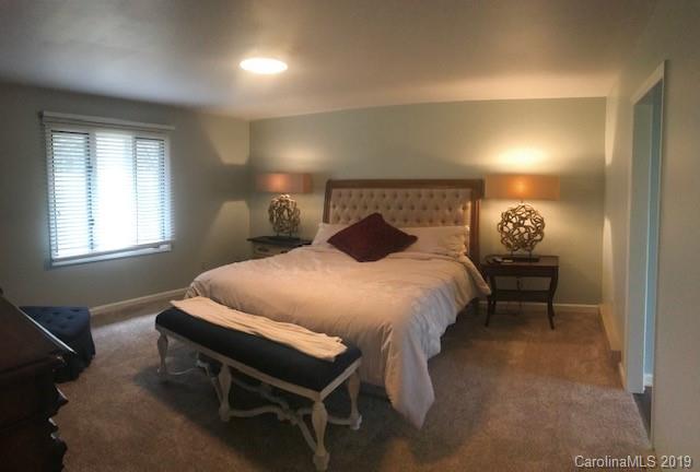 212 Pine Ridge Road Beech Mountain, NC 28604 - Photo 23 of 27 a bed sitting in a bedroom next to a window and lamp