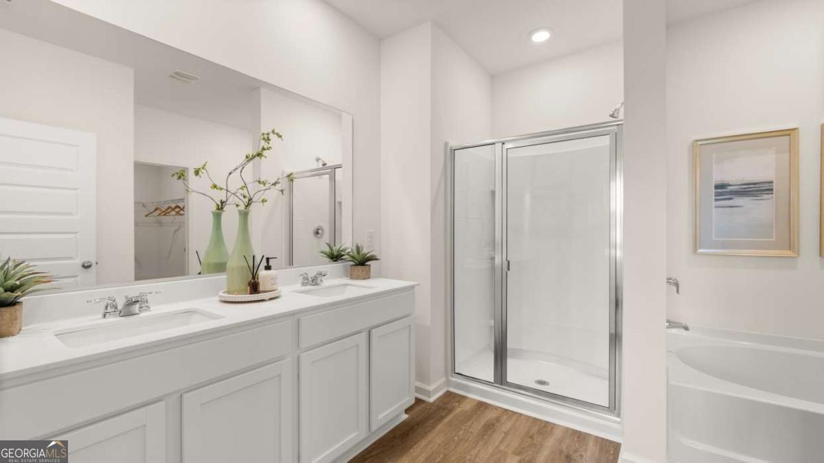 111 Cattle Drive Perry, GA 31069 - Photo 14 of 47 a bathroom with a double vanity sink a mirror a bathtub and shower