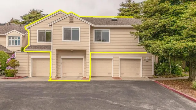a view of a white house with large windows and a yard