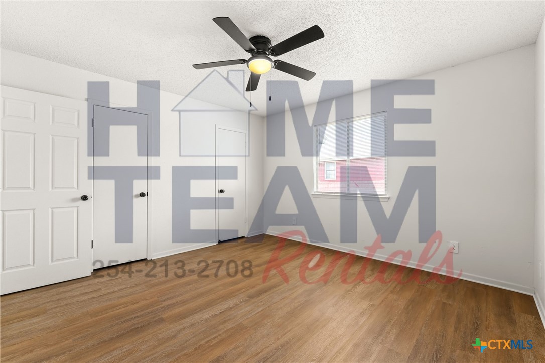 1005 Eastside Drive, Unit B Killeen, TX 76543 - Photo 11 of 11 a view of an empty room with wooden floor and a ceiling fan
