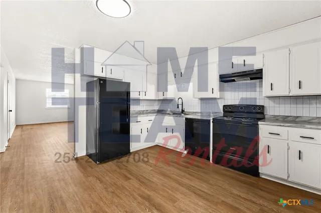 a kitchen with stainless steel appliances a refrigerator sink and cabinets