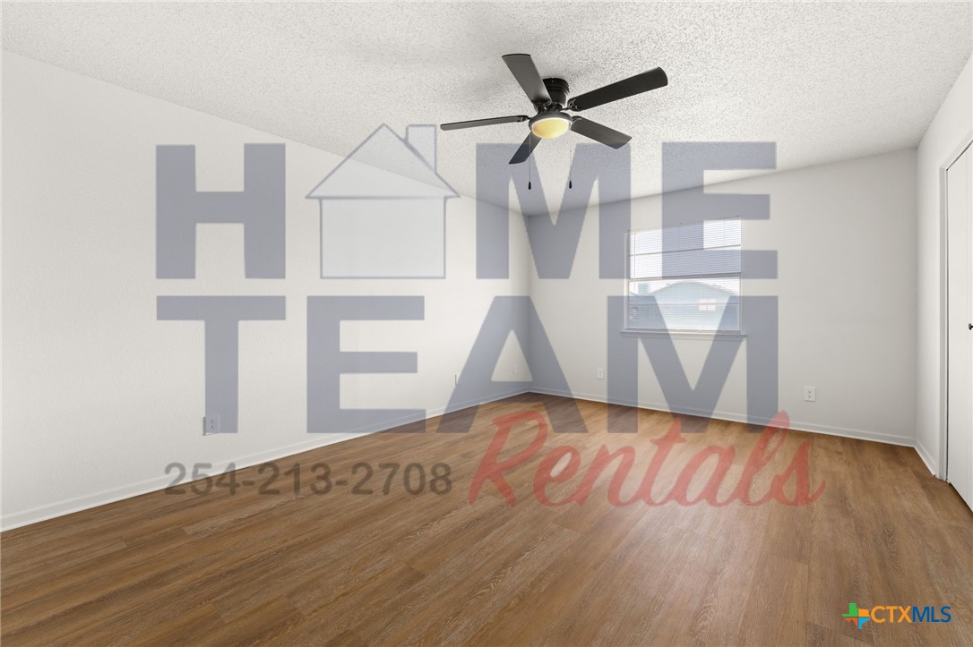 1005 Eastside Drive, Unit B Killeen, TX 76543 - Photo 7 of 11 an empty room with wooden floor and windows