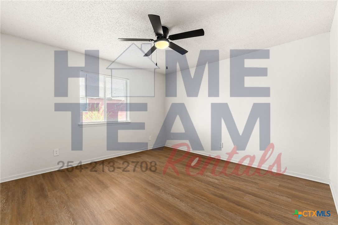 1005 Eastside Drive, Unit B Killeen, TX 76543 - Photo 10 of 11 a view of an empty room with wooden floor and a ceiling fan