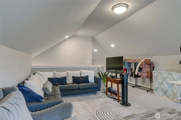 a living room with furniture a bookshelf and a window