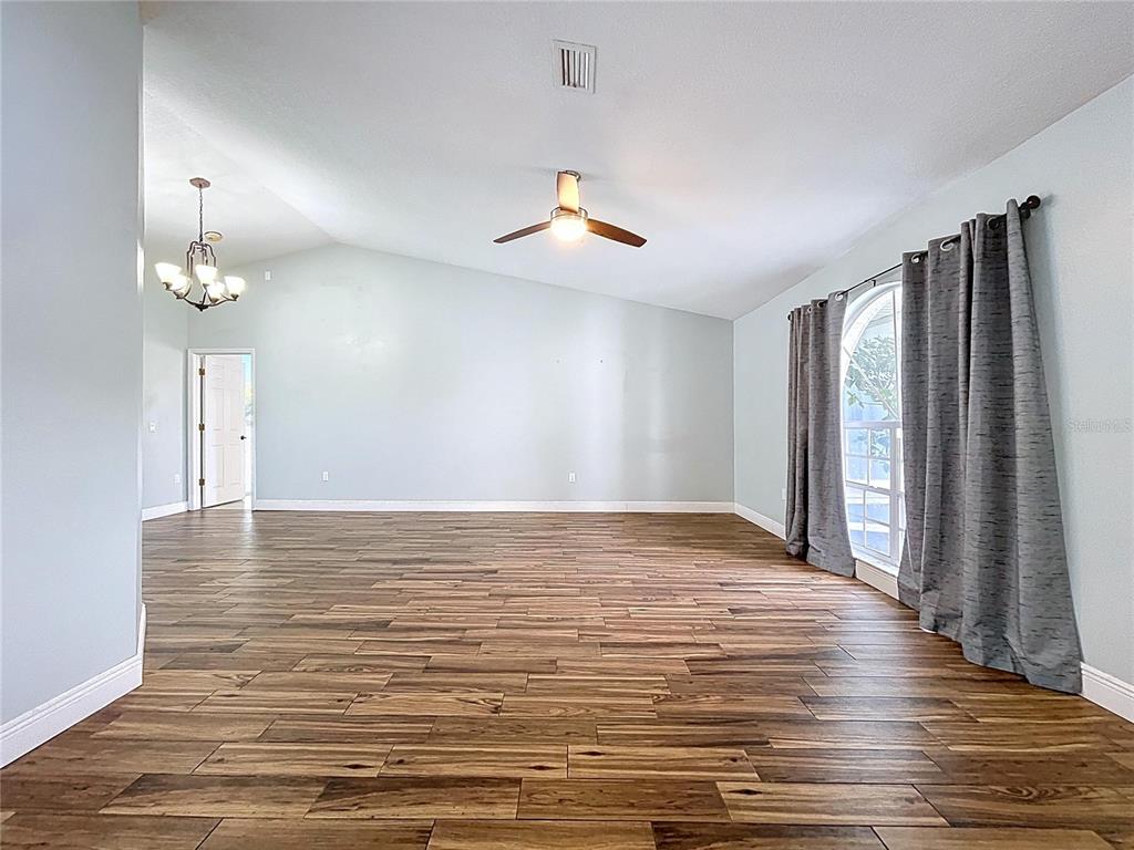 18812 Bascomb Lane Hudson, FL 34667 - Photo 16 of 57 a view of an empty room with wooden floor and a window