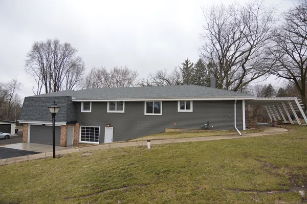 a front view of house with yard and trees in the background