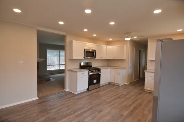a view of a kitchen with a refrigerator and a stove top oven