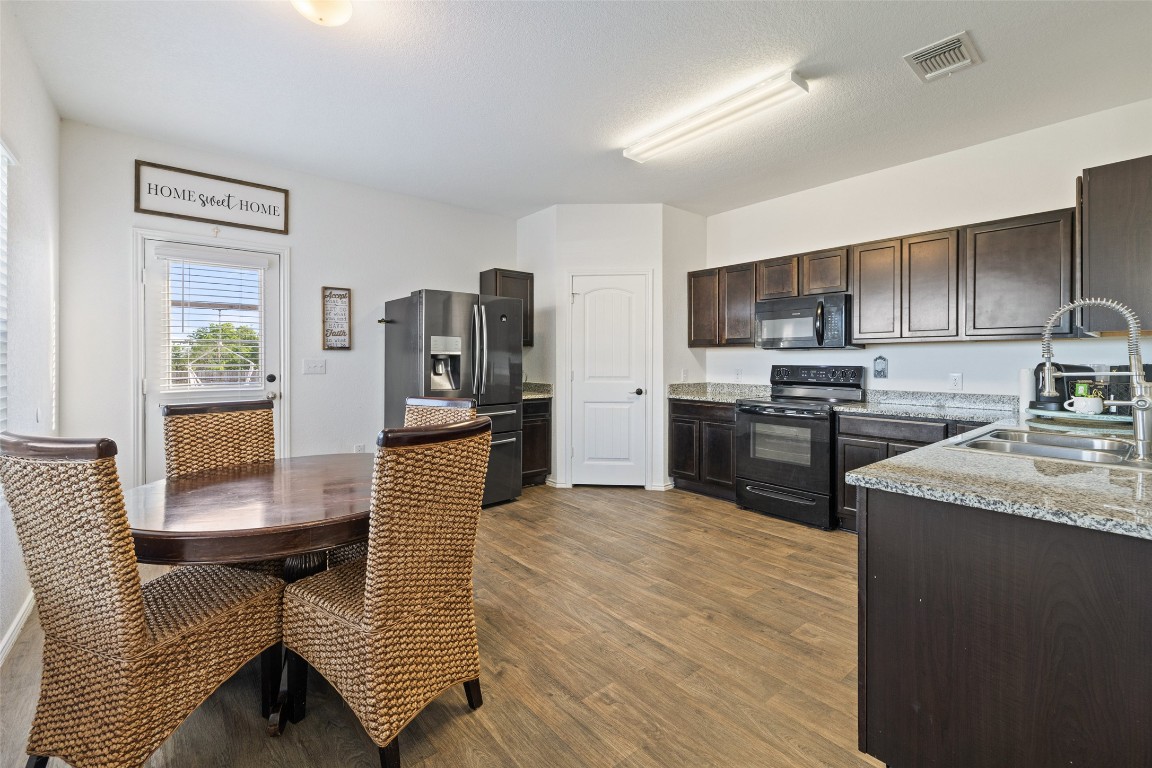 11801 Riprap Drive Manor, TX 78653 - Photo 14 of 40 a kitchen with stainless steel appliances granite countertop a refrigerator stove microwave and sink