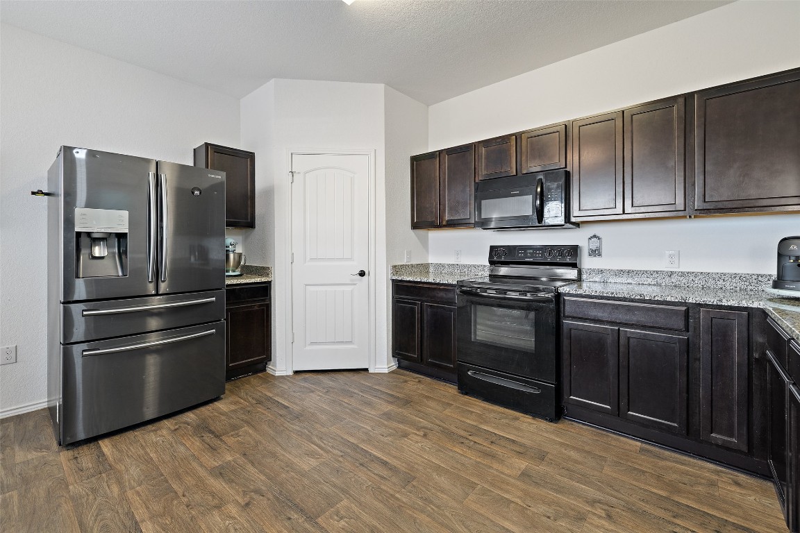 11801 Riprap Drive Manor, TX 78653 - Photo 15 of 40 a kitchen with stainless steel appliances and wooden cabinets