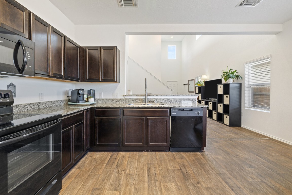 11801 Riprap Drive Manor, TX 78653 - Photo 18 of 40 a kitchen with stainless steel appliances granite countertop a stove a sink and a microwave