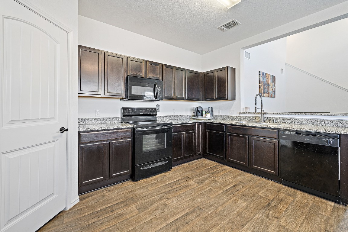 11801 Riprap Drive Manor, TX 78653 - Photo 19 of 40 a kitchen with stainless steel appliances granite countertop a stove sink and refrigerator