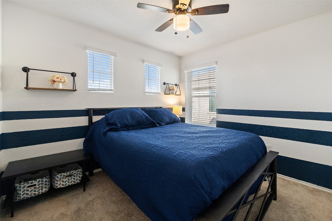 11801 Riprap Drive Manor, TX 78653 - Photo 26 of 40 a bedroom with a bed and a chandelier