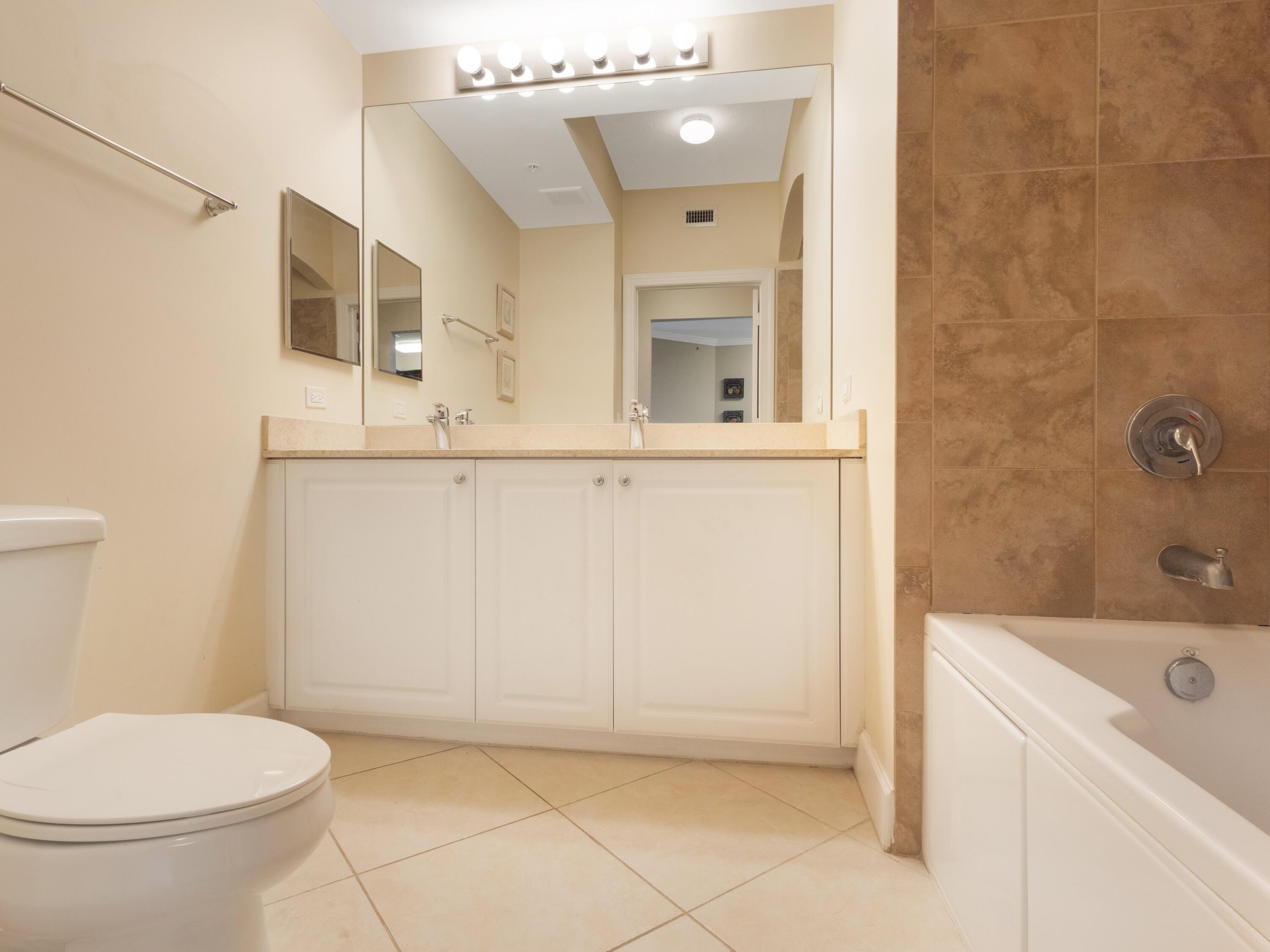 1690 Renaissance Commons Boulevard, Unit 1412 Boynton Beach, FL 33426 - Photo 17 of 49 a bathroom with a sink a toilet and shower
