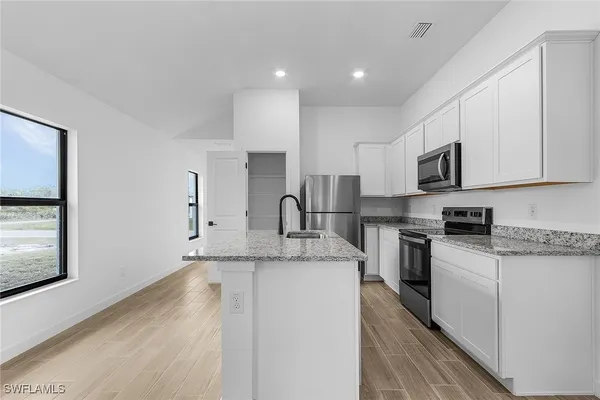 a kitchen with stainless steel appliances granite countertop a sink stove and microwave