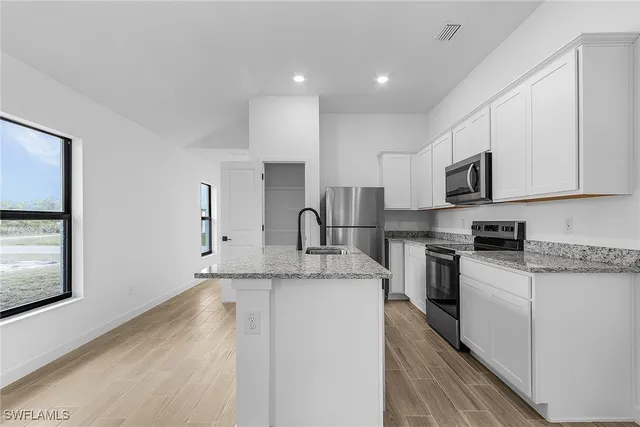 a kitchen with stainless steel appliances granite countertop a sink stove and microwave