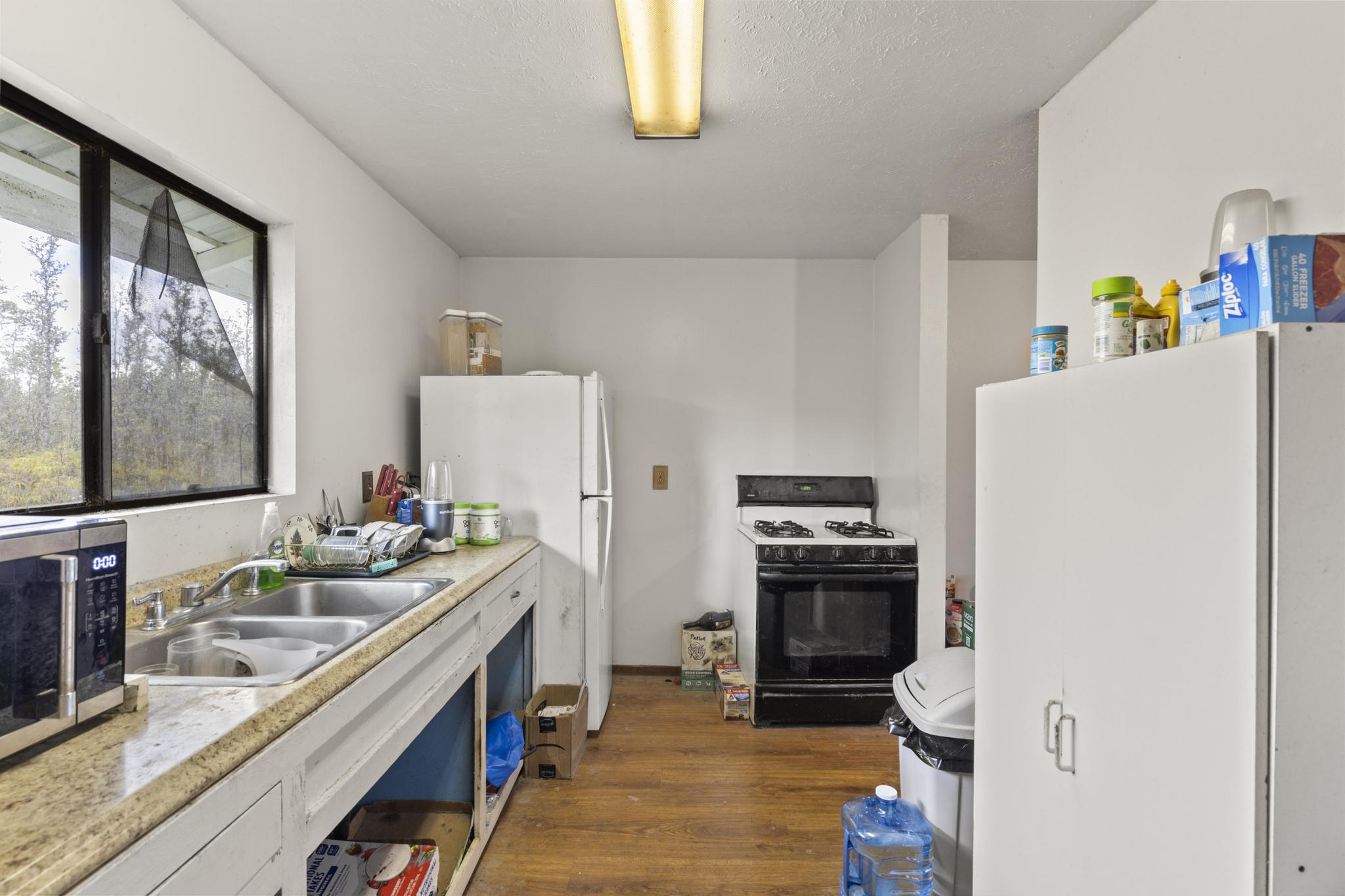 16-2071 Ao Rd Mountain View Pahoa, HI 96778 - Photo 7 of 13 a kitchen with a refrigerator and a stove top oven
