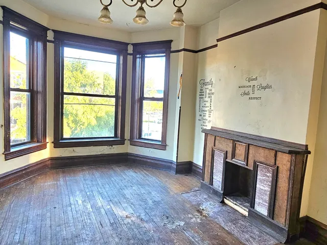 a view of an empty room with a fireplace and a window