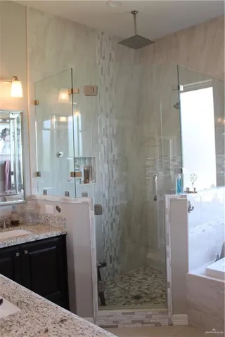 a bathroom with a granite countertop sink a shower and a mirror