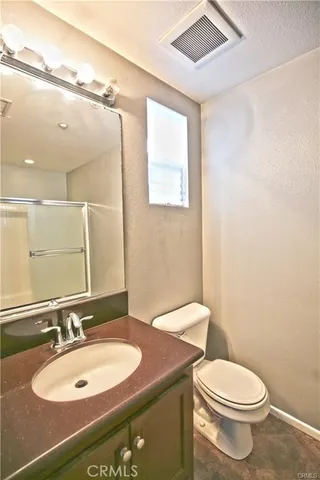 a bathroom with a sink a toilet and mirror