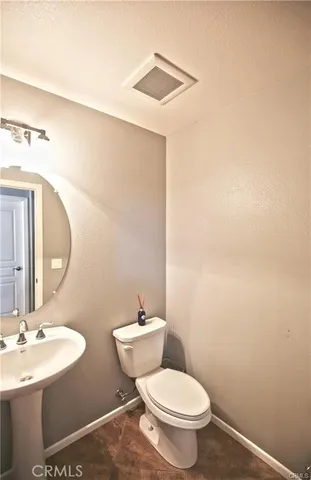 a bathroom with a toilet a sink and mirror