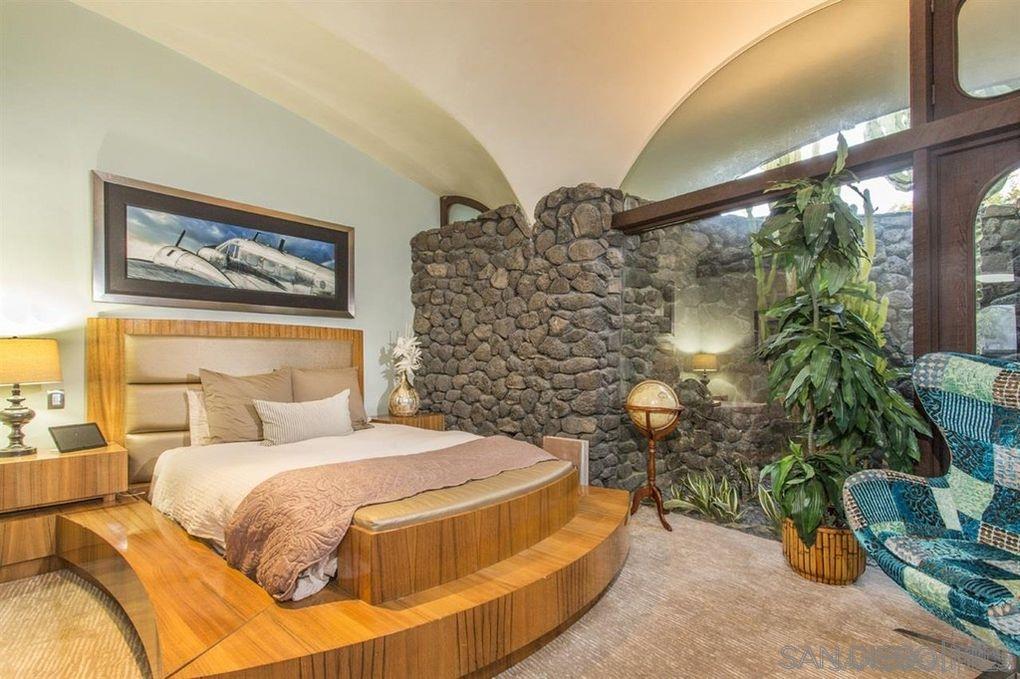 9805 Blackgold Road La Jolla, CA 92037 - Photo 9 of 32 a spacious bedroom with a bed and a potted plant