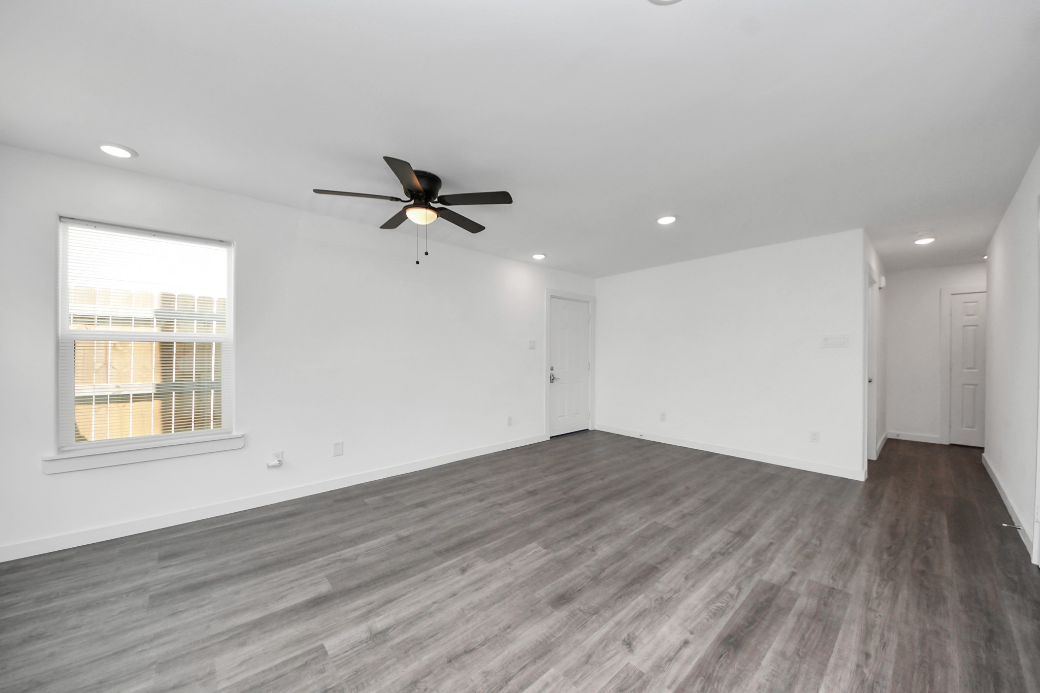 8125 Laura Koppe Road, Unit A Houston, TX 77028 - Photo 16 of 38 an empty room with wooden floor fan and windows