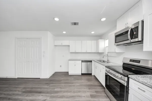 a kitchen with a refrigerator and a stove top oven