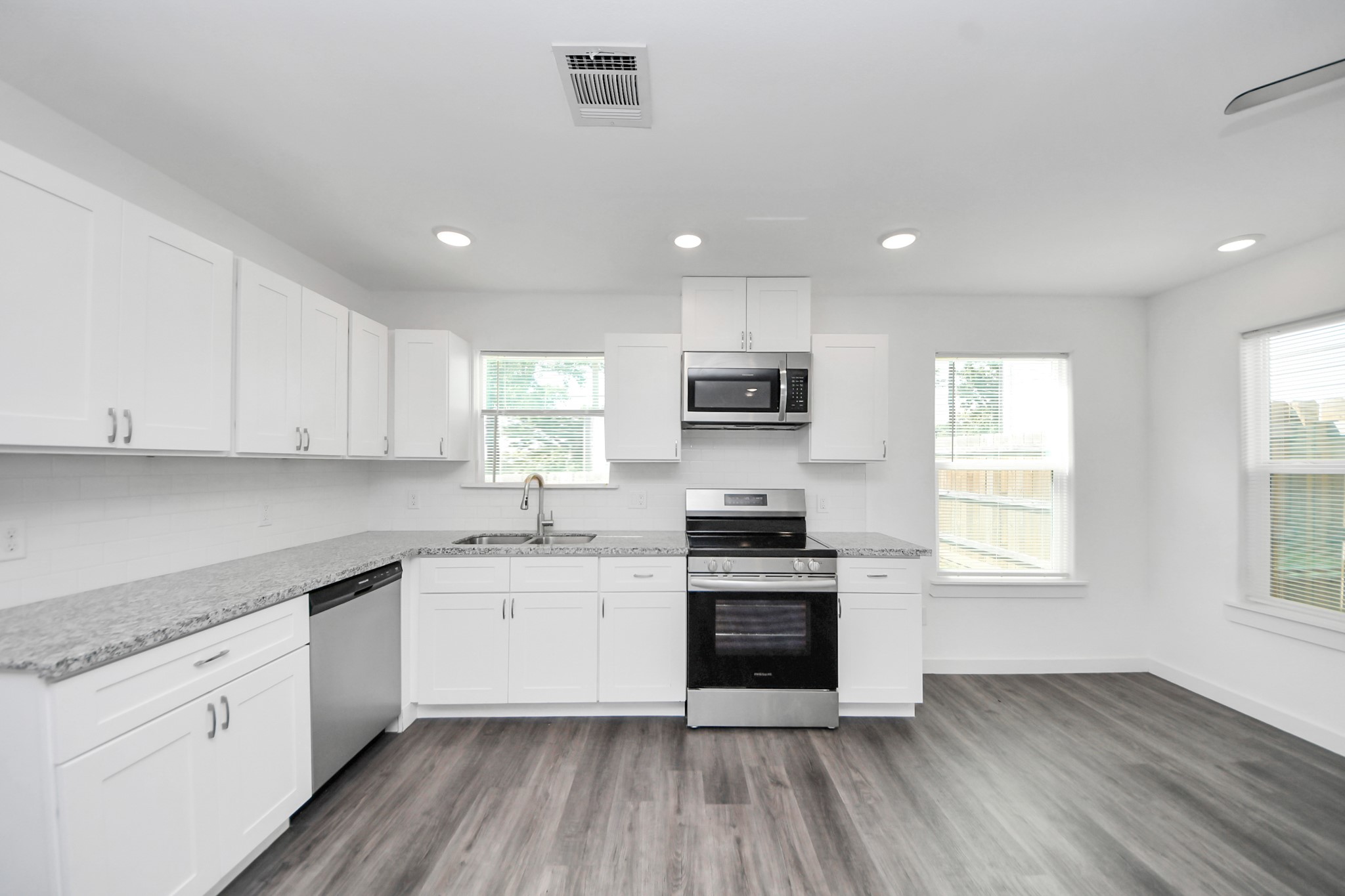 8125 Laura Koppe Road, Unit A Houston, TX 77028 - Photo 9 of 38 a kitchen with granite countertop a sink wooden floor and stainless steel appliances