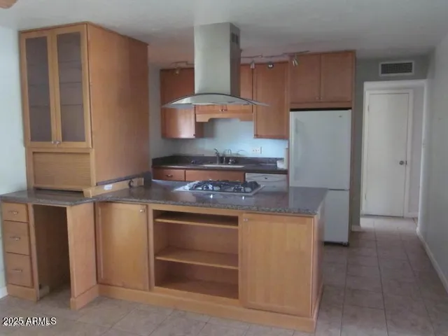 a kitchen with stainless steel appliances granite countertop a stove a refrigerator and a cabinets