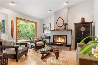 a living room with furniture fireplace and a large window