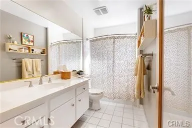 a bathroom with a double vanity sink toilet and shower