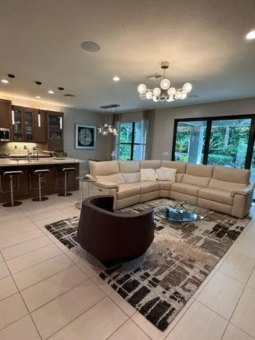 a living room with lots of furniture and kitchen view