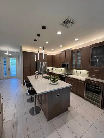 a kitchen with stainless steel appliances kitchen island granite countertop a sink and cabinets
