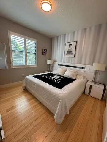 a bedroom with a bed and wooden floor