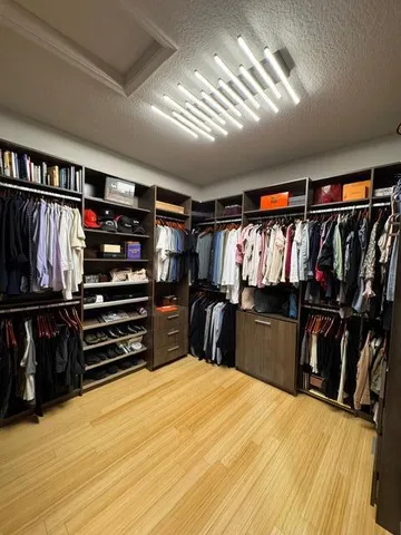 a view of walk in closet with clothes and shoes