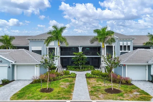 a front view of a house with a yard and potted plants