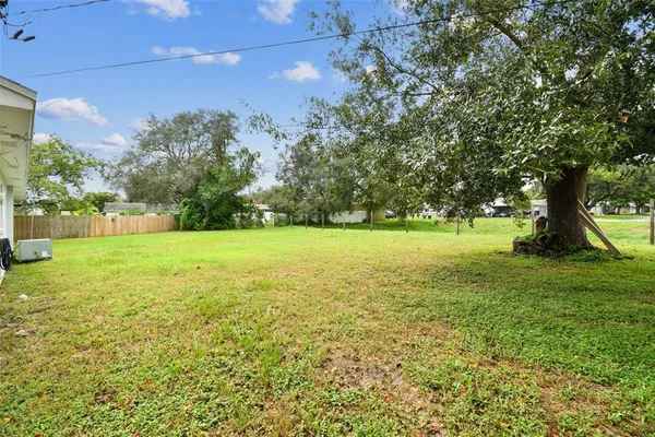 a view of a yard with a car parked in front of a house