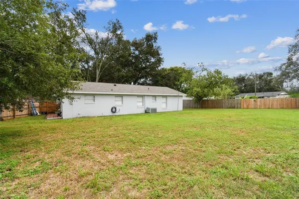 a front view of a house with garden and trees