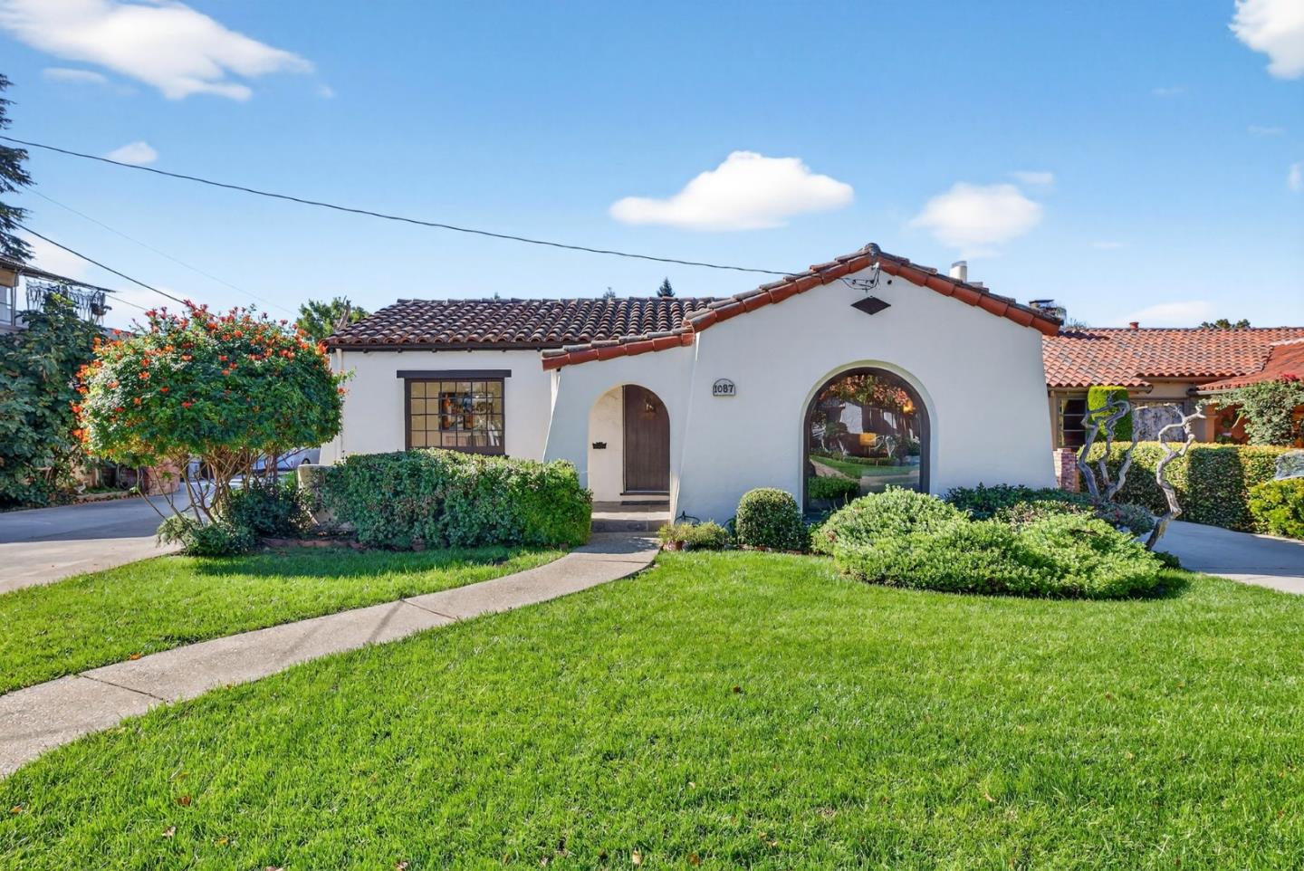 a front view of house with garden and trees