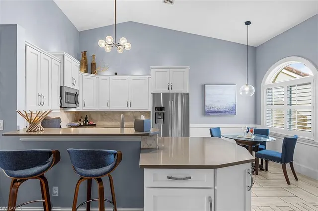a kitchen with stainless steel appliances a dining table chairs and chandelier
